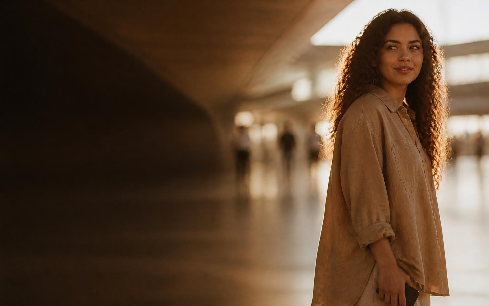 Mujer joven en una terminal, luz cálida de tarde